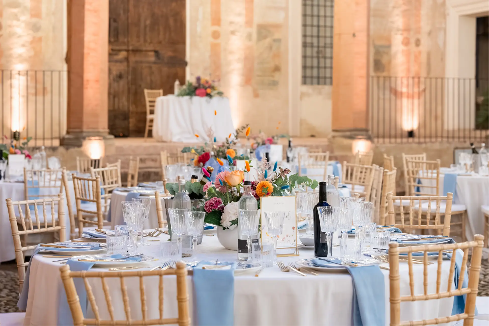 Tavolo apparecchiato con fiori e mise en place elegante in una corte storica