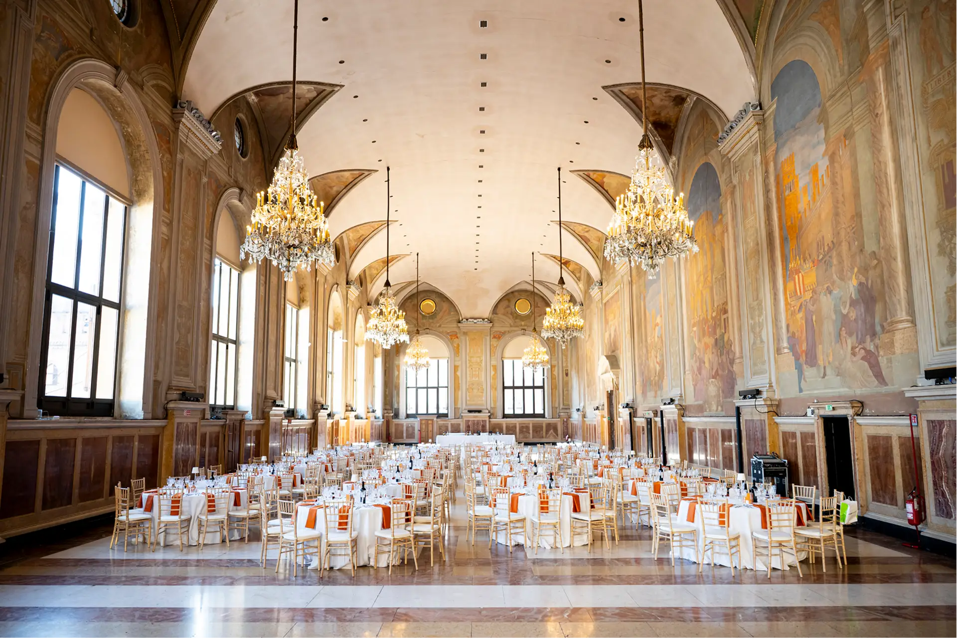 Sala storica con lampadari e mise en place per grande ricevimento o matrimonio