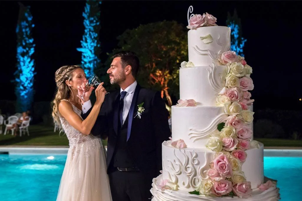 Sposi con torta nuziale scenografica realizzata da Il Mago delle Torte durante evento serale