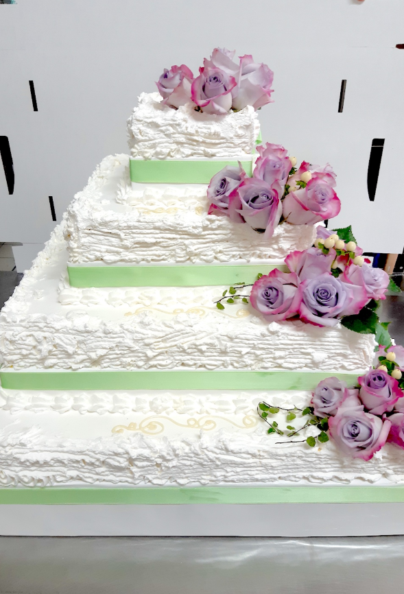 Torta nuziale artigianale decorata con frutti di bosco freschi