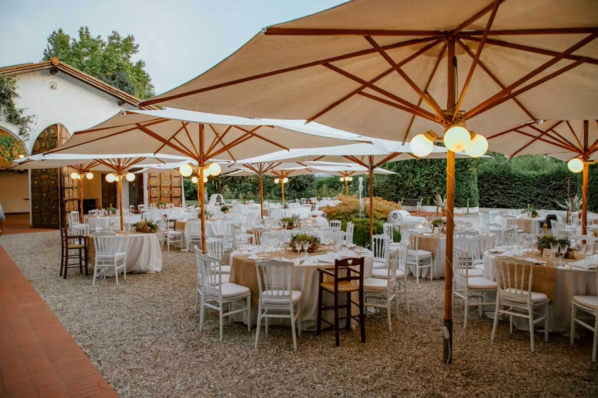 Allestimento all’aperto presso Villa Cà Bianca con tavoli in legno e fiori freschi